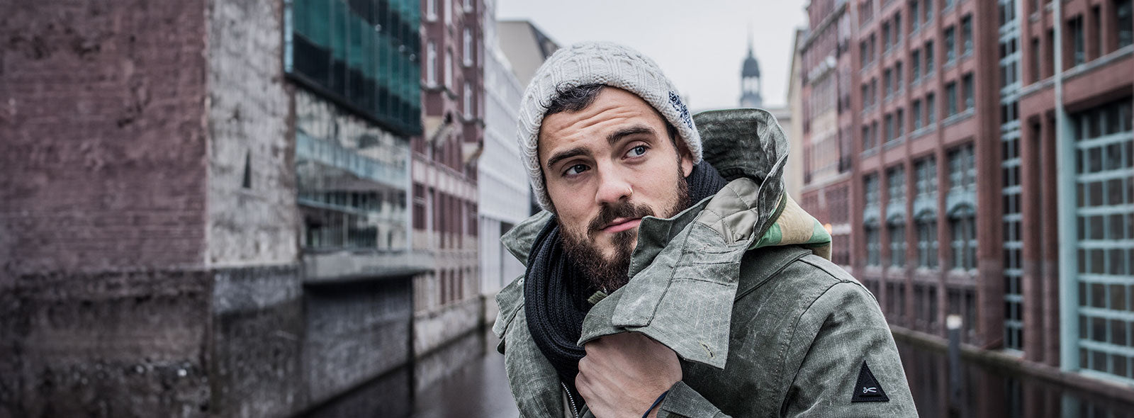 Website Slider Winter - Mann mit Bart in Stadtkulisse